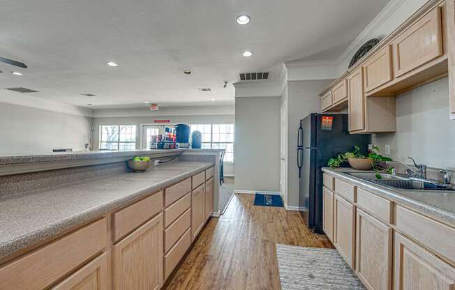 A kitchen with wooden cabinets and a black refrigerator.