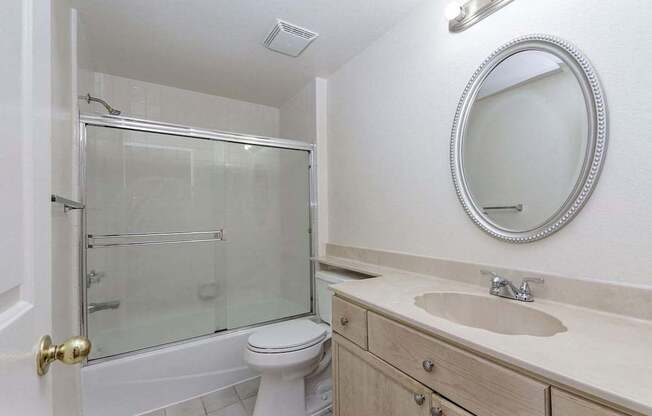 A bathroom with a toilet, sink, and shower.