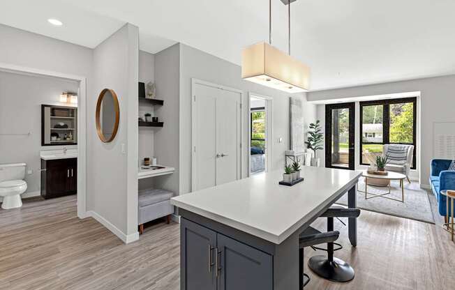 A modern kitchen with a large island and a view of the backyard.