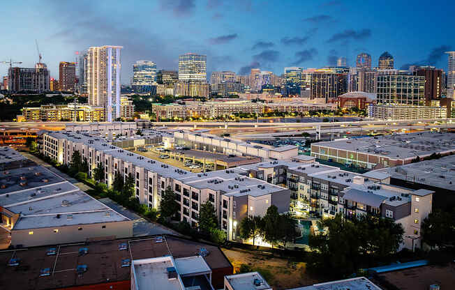 A cityscape at dusk with a mix of residential and commercial buildings.