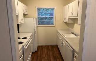 a kitchen with white appliances and white cabinets