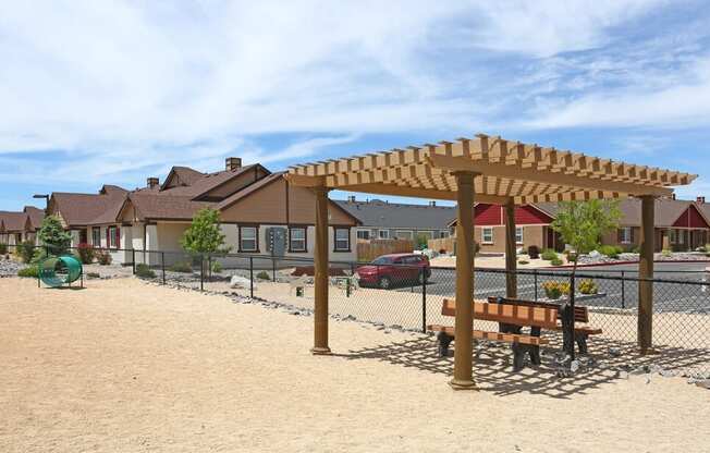 a playground with a picnic table and a pergola