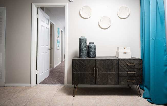 a hallway with a dresser and a door to a room with blue curtains at Fairways of Inverrary, Lauderhill, FL, 33319