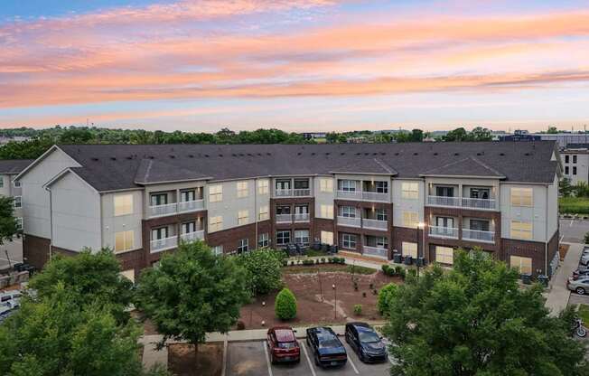 A large apartment complex with a parking lot in front.