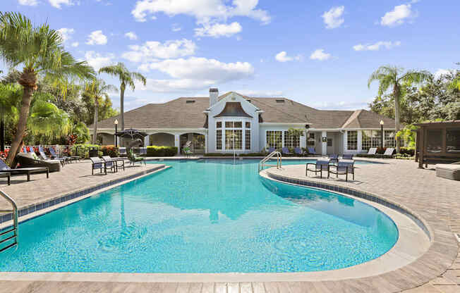 a large swimming pool with a house in the background