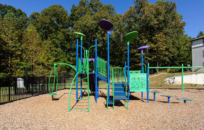 a playground with a blue and green swing set