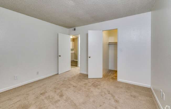 an empty living room with white walls and carpeting