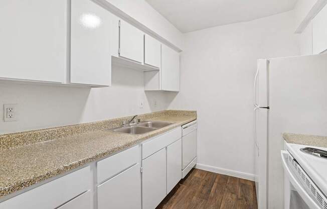 A kitchen with white cabinets and a granite countertop.
