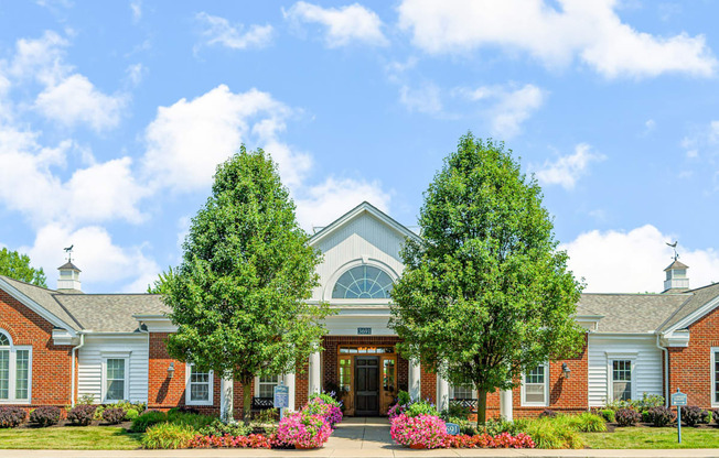 the front of a building with two trees in front of it