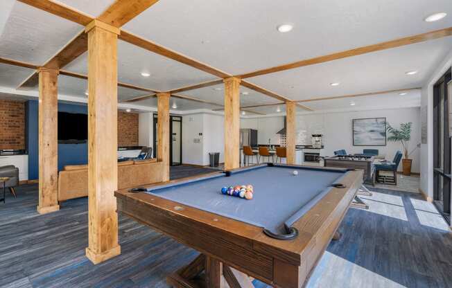 a pool table in the clubhouse of a home with a living room