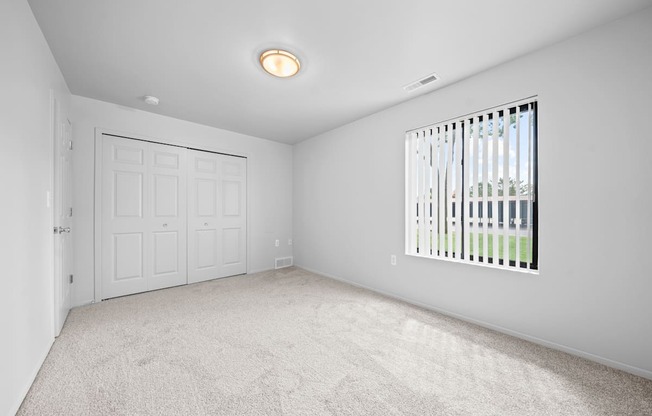 A white room with a door, window, and carpet.