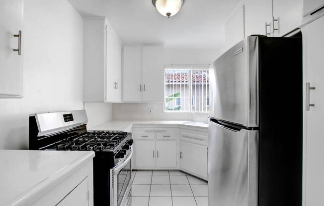 a white kitchen with a stove and a refrigerator