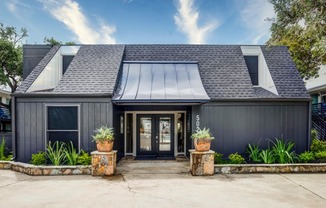 a house with a black exterior and a gray roof