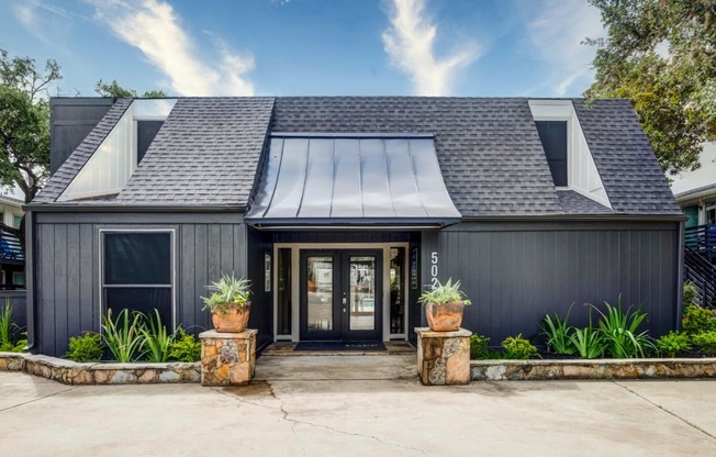 a house with a black exterior and a gray roof