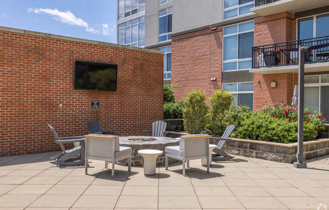 a patio with a table and chairs in front of a building