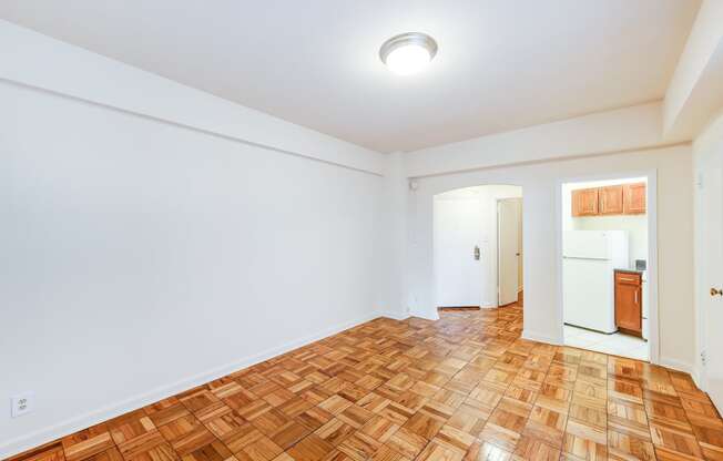 vacant living area with hardwood floors and view of kitchen  at baystate apartments in washington dc