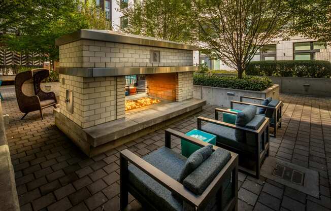 a patio with a fireplace and lounge chairs at The Parker, Portland, OR