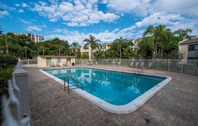 a swimming pool at an apartment complex with palm trees at Fairways of Inverrary, Florida, 33319