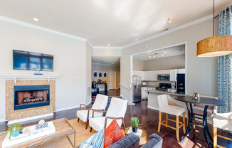 a living room with a fireplace and a kitchen with a table and chairs