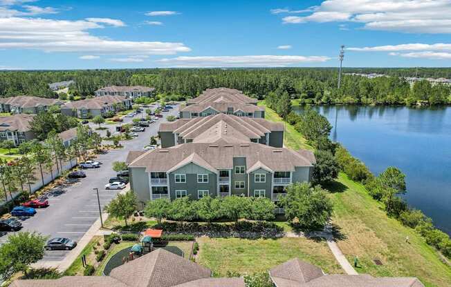 A large house with a green lawn in front of a lake.