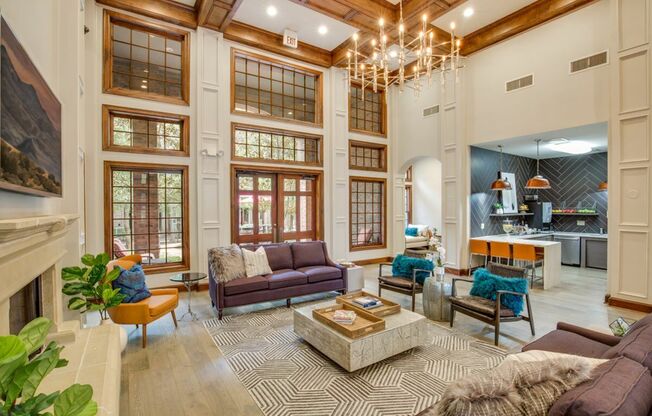 View of Resident Clubhouse with Fireplace, Ceiling Fan, and View of Community Kitchen at Raveneaux Apartments