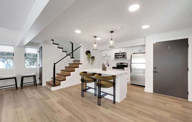 A modern kitchen with a dining table and chairs.