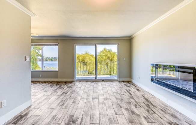 an empty living room with sliding glass doors and a view of the lake