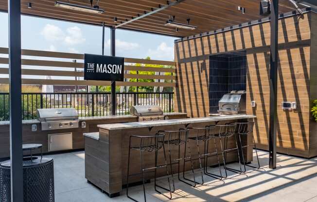 an outdoor patio with a grill and a bar