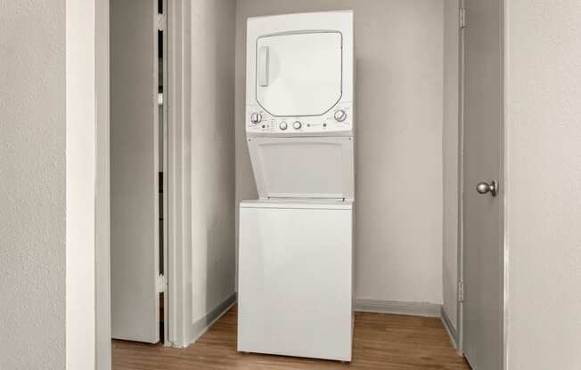 a white washer and dryer in a room with a door at South Lamar Village, Austin, TX