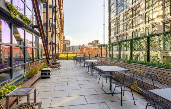 an outdoor patio with tables and chairs on a city street