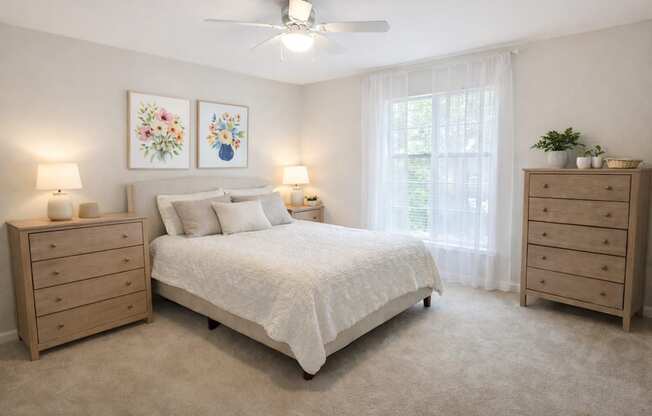A bedroom with a bed, two nightstands, and a ceiling fan.