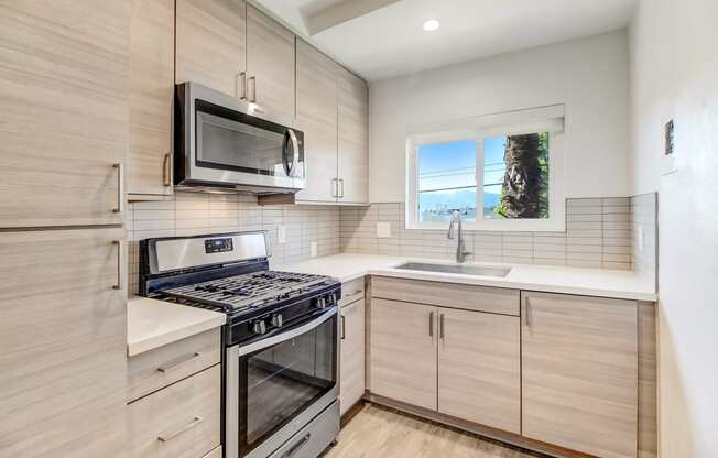 an updated kitchen with stainless steel appliances and wooden cabinets