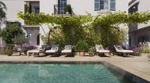 a swimming pool and lounge chairs in front of a building