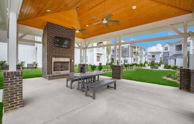 A patio with a table and chairs and a fireplace.