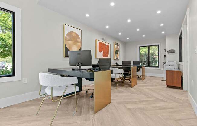 A modern home office with a desk, chairs, and a computer.