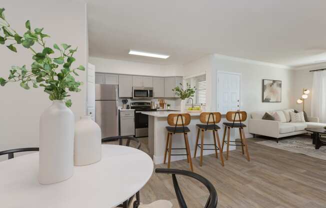 a living room with a kitchen and a table with chairs