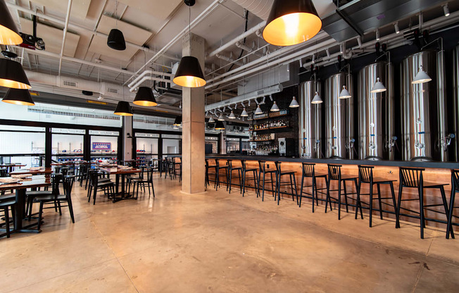 the bar and dining area of a restaurant with tables and chairs