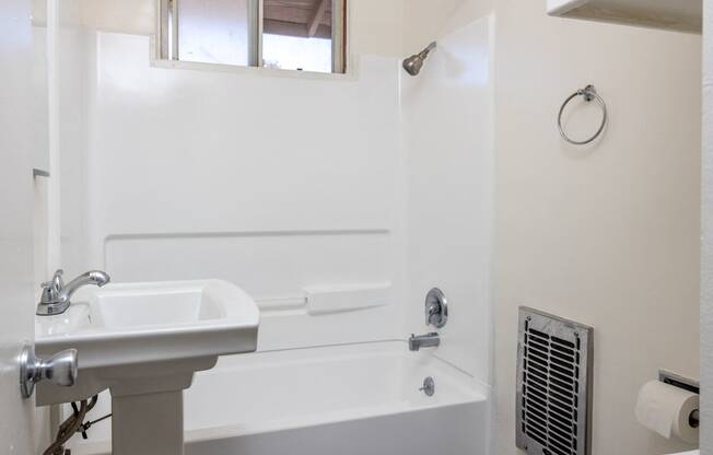 a bathroom with a sink and a tub and a window