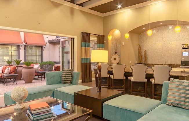 a living room with blue couches and chairs and a dining room with a table and chairs