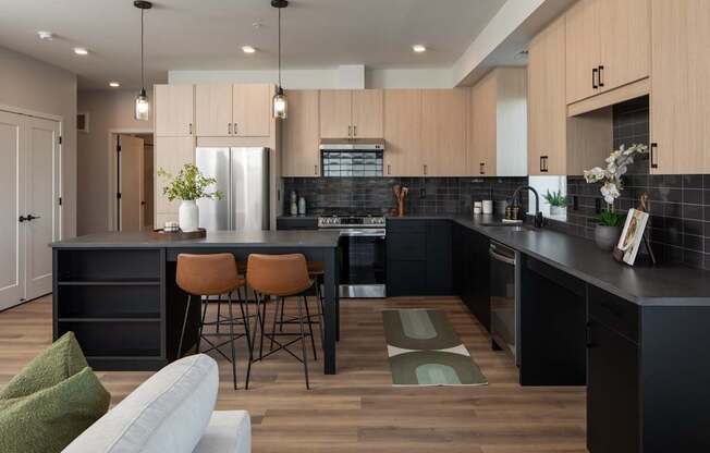 A modern kitchen with a black countertop and wooden cabinets.