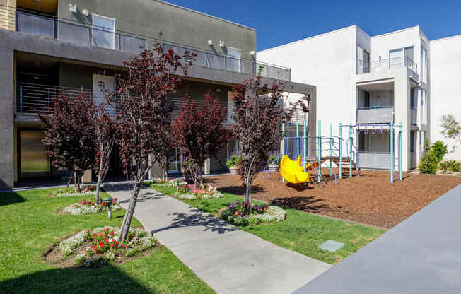 a courtyard with a yellow swing set in front of a building