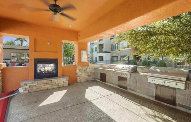 A patio with a fireplace and a grill.