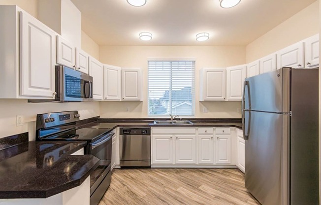 a kitchen with stainless steel appliances and white cabinets