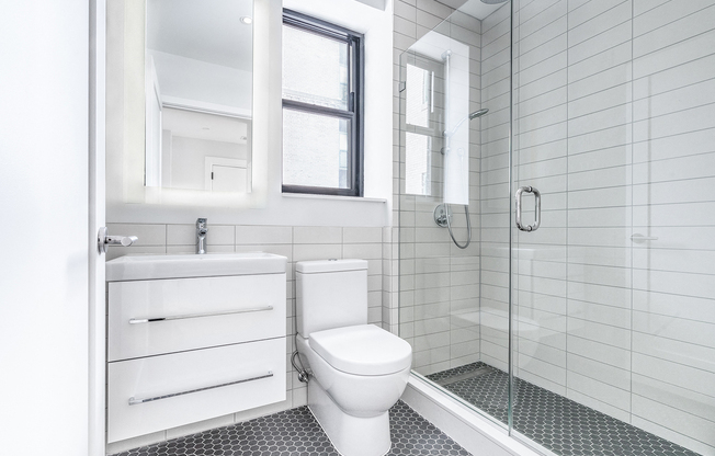 Bright tiled bathrooms with large backlit designer mirror, Hans Grohe chrome fixtures and Villeroy & Boch vanity