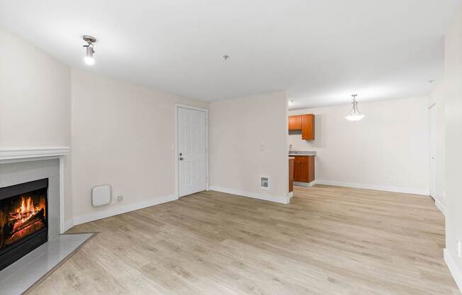 A room with a fireplace and wooden flooring.