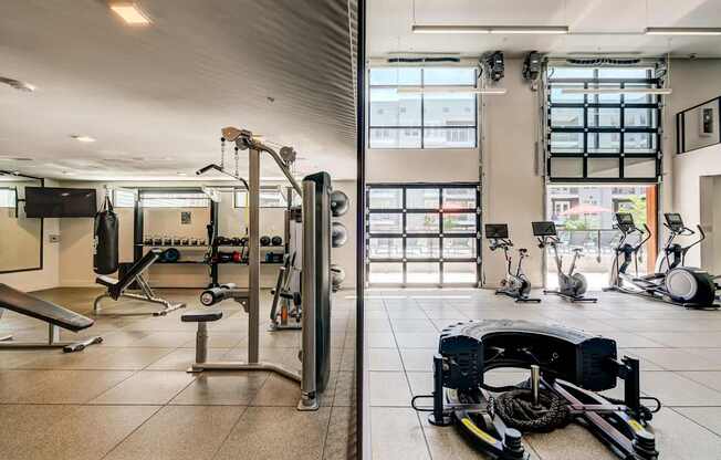 A gym with a variety of equipment including weights and exercise machines.