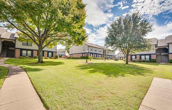 A grassy area in front of apartment buildings.