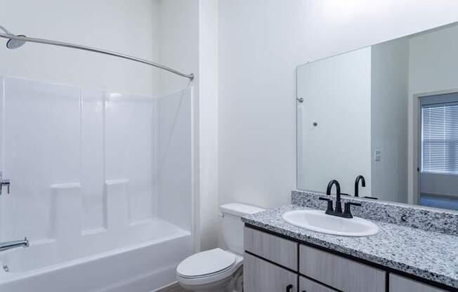 A white bathroom with a toilet, sink, and bathtub.