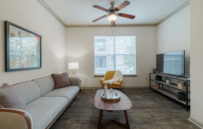 a living room with a ceiling fan and a couch