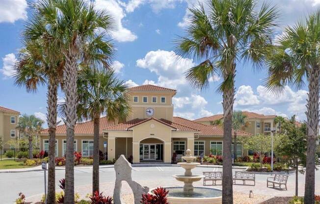 a courtyard with a fountain and palm trees in front of a building